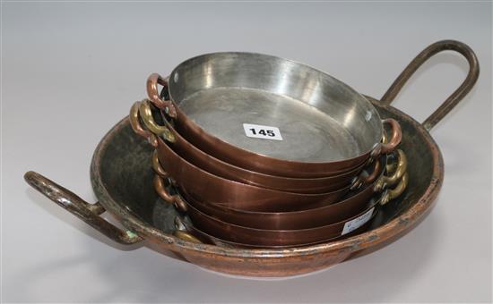 A large copper 2 handled dish and 6 smaller dishes Dia.18cm